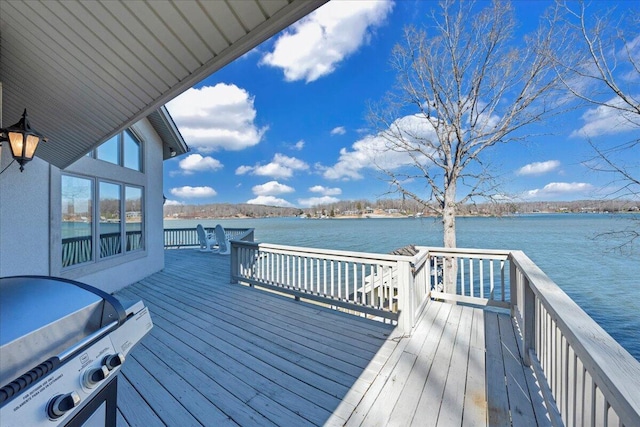 wooden terrace featuring grilling area and a water view