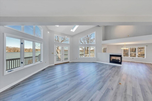 unfurnished living room with visible vents, plenty of natural light, and wood finished floors