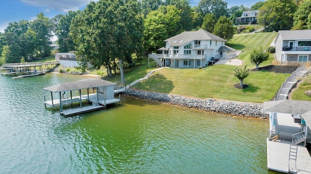 view of dock featuring a lawn, a deck with water view, and boat lift