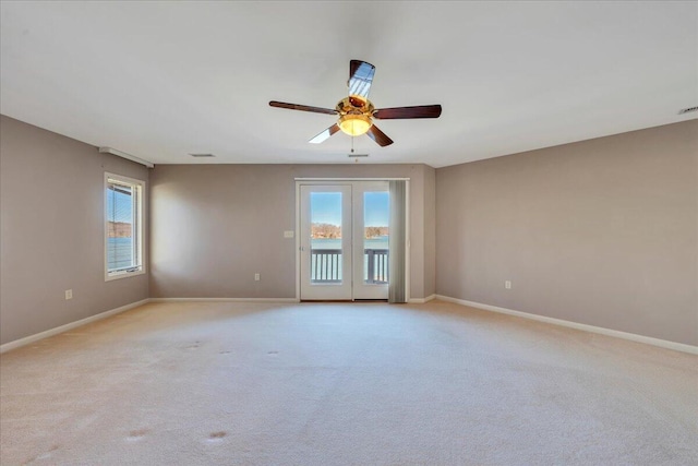 spare room featuring plenty of natural light, baseboards, and ceiling fan