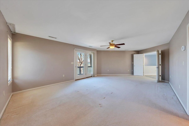 unfurnished room with visible vents, baseboards, light carpet, and ceiling fan