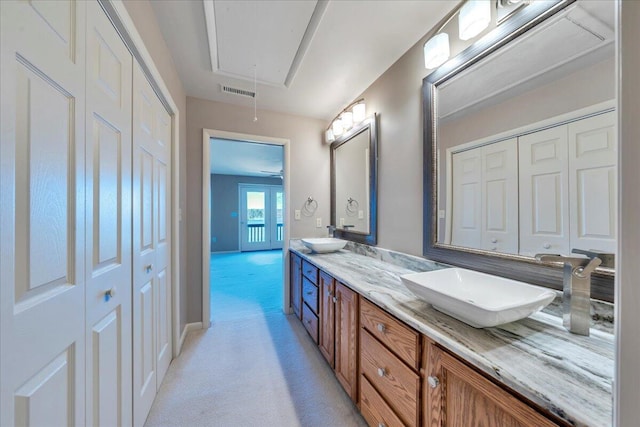 full bath with a sink, visible vents, a closet, and double vanity