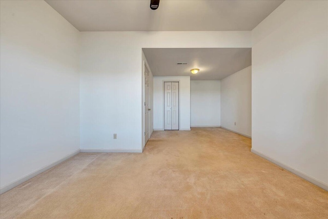 unfurnished room with baseboards and light carpet