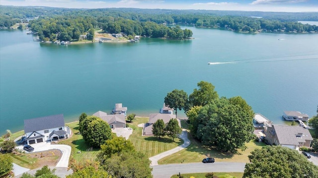 drone / aerial view with a wooded view and a water view