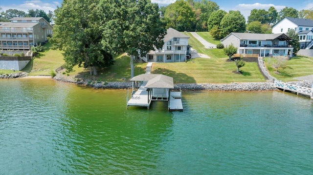 view of dock with boat lift, a yard, and a water view