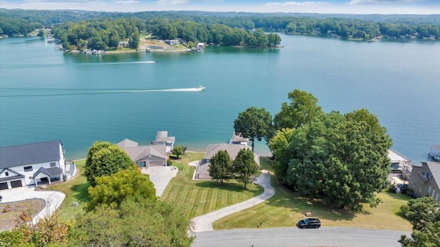drone / aerial view featuring a wooded view and a water view
