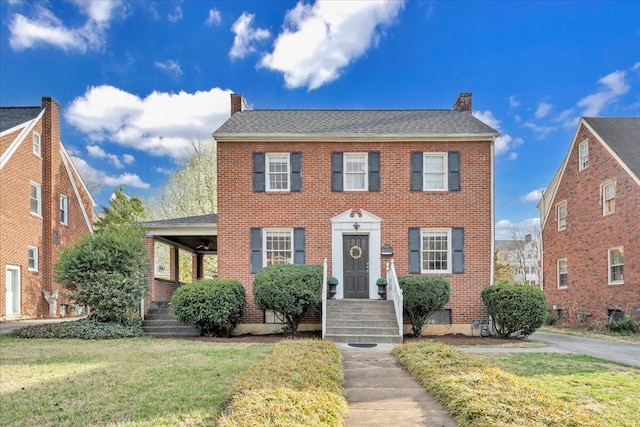1656 Brandon Ave SW, Roanoke, VA 24015 - colonial inspired home featuring a chimney, a front lawn, and brick siding