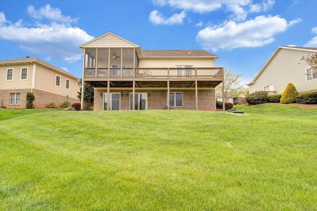rear view of property featuring a yard, a deck, and a sunroom