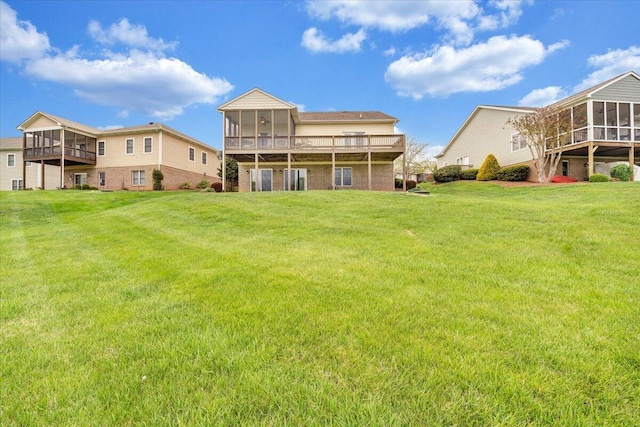 rear view of house with a sunroom and a lawn