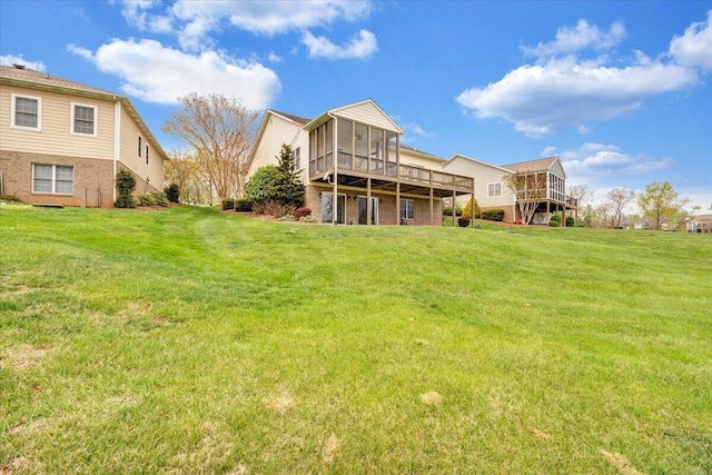 back of house featuring a yard, a deck, and a sunroom