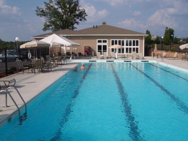 community pool featuring a patio area and fence