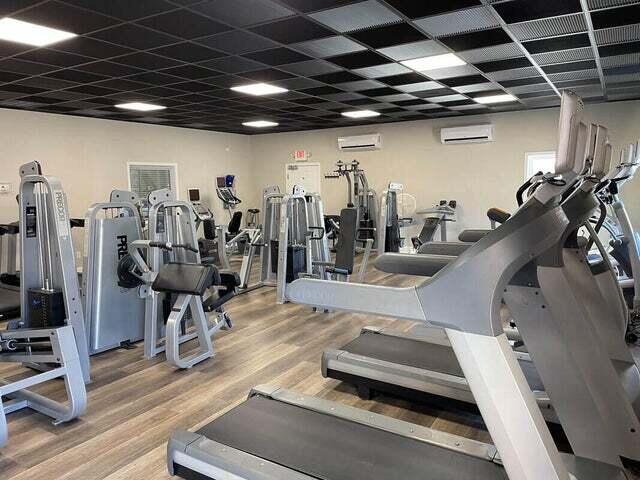 workout area featuring a wall mounted AC and wood finished floors