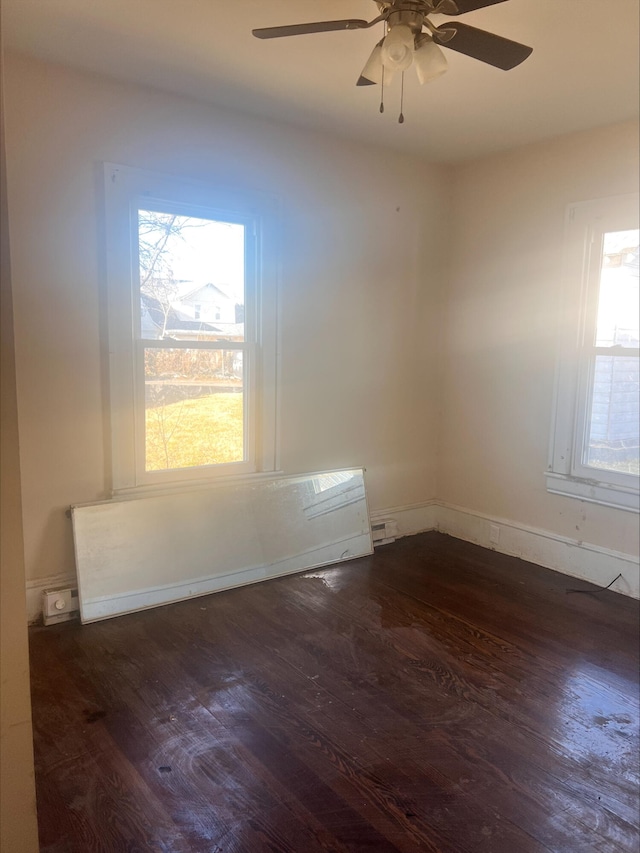 empty room with baseboards, wood finished floors, and a ceiling fan