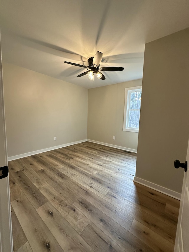 unfurnished room with visible vents, hardwood / wood-style flooring, baseboards, and ceiling fan