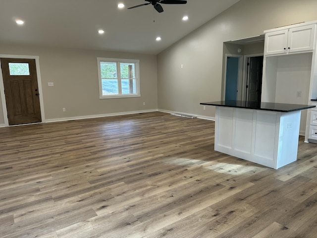 unfurnished living room with wood finished floors, recessed lighting, vaulted ceiling, and ceiling fan