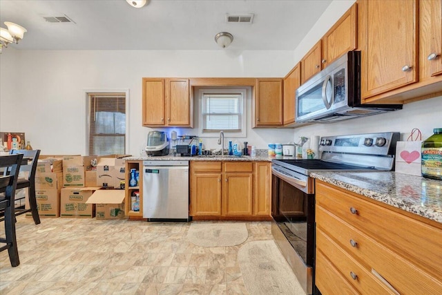 728 Jamison Ave SE, Roanoke, VA 24013 - kitchen with a sink, stainless steel appliances, light stone counters, and visible vents