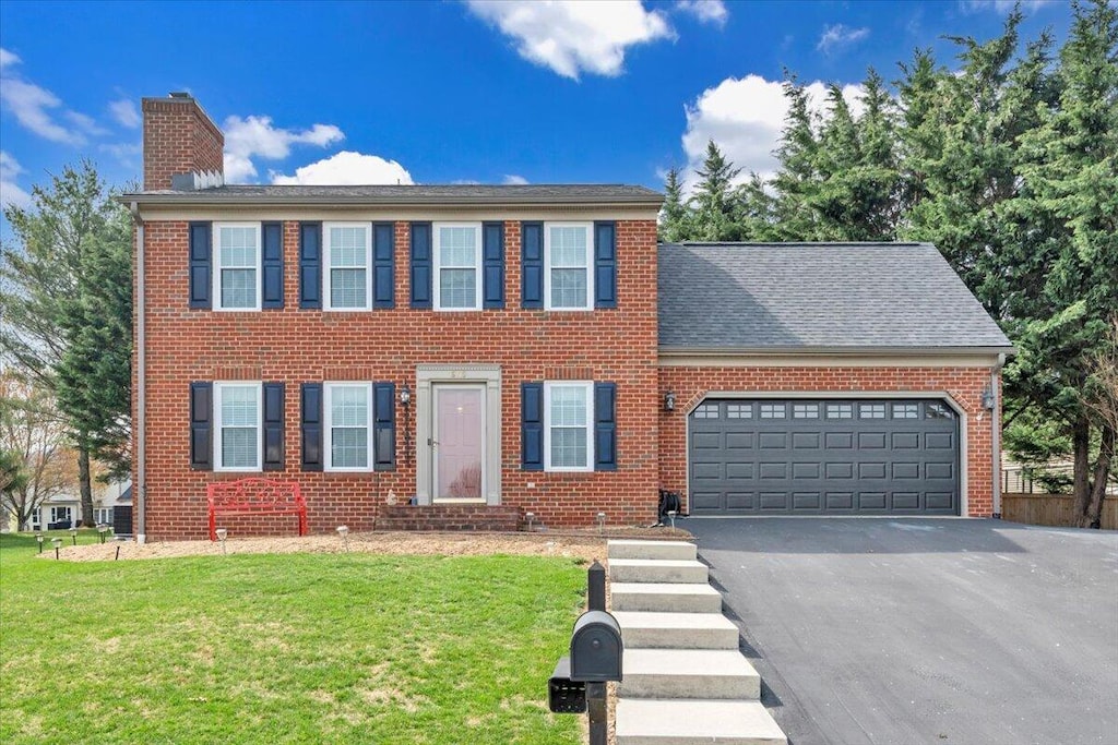 6115 Ashmont Dr, Roanoke, VA 24018 - colonial home featuring an attached garage, aphalt driveway, a chimney, and a front yard