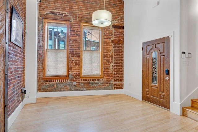 133 Norfolk Ave SW, Roanoke, VA 24011 - entrance foyer with baseboards, wood finished floors, brick wall, and stairs