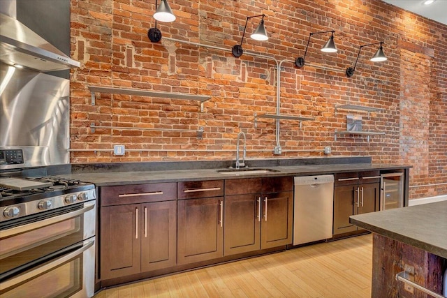 133 Norfolk Ave SW, Roanoke, VA 24011 - kitchen featuring stainless steel appliances, a sink, brick wall, and dark countertops