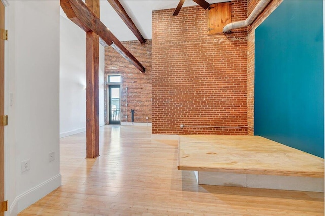 133 Norfolk Ave SW, Roanoke, VA 24011 - interior space featuring brick wall, wood finished floors, a high ceiling, baseboards, and beamed ceiling
