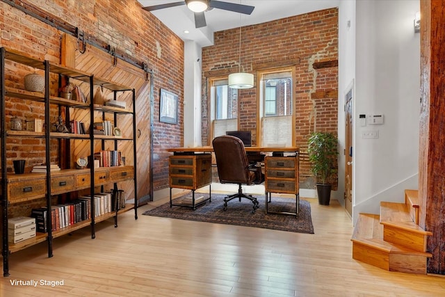 133 Norfolk Ave SW, Roanoke, VA 24011 - office space featuring brick wall, a ceiling fan, wood-type flooring, a high ceiling, and a barn door