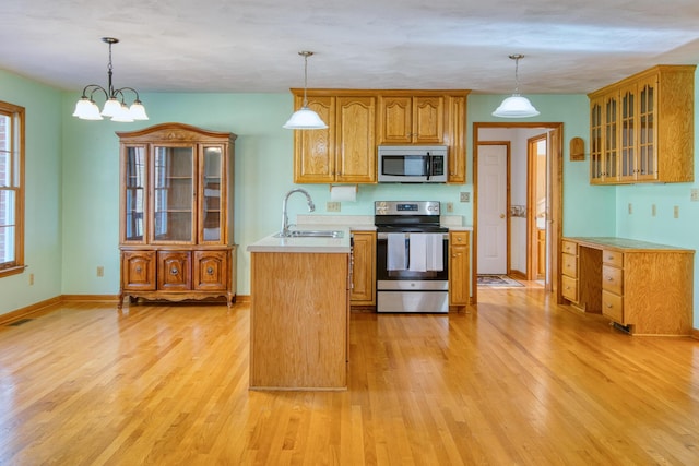 195 Showalter Rd NW, Willis, VA 24380 - kitchen with appliances with stainless steel finishes, light countertops, light wood finished floors, brown cabinets, and glass insert cabinets