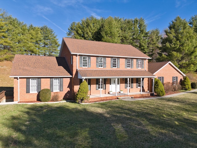 195 Showalter Rd NW, Willis, VA 24380 - colonial-style house with covered porch, brick siding, a front lawn, and roof with shingles