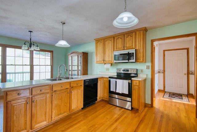 195 Showalter Rd NW, Willis, VA 24380 - kitchen with stainless steel appliances, a peninsula, light countertops, light wood-style flooring, and decorative light fixtures