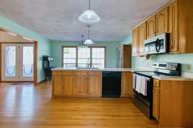 195 Showalter Rd NW, Willis, VA 24380 - kitchen featuring appliances with stainless steel finishes, a peninsula, light wood-style flooring, light countertops, and decorative light fixtures