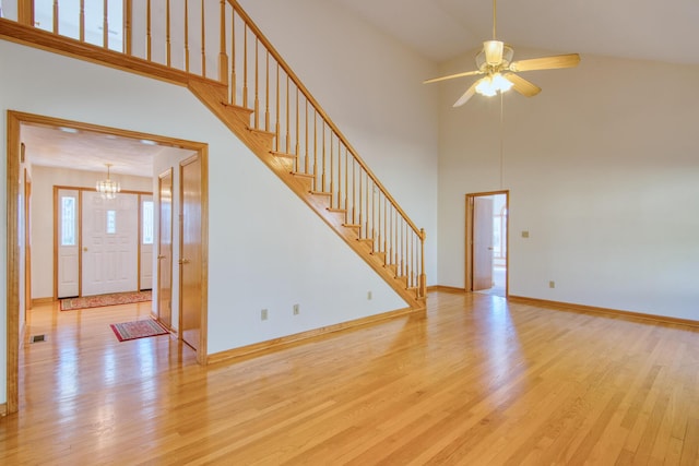 195 Showalter Rd NW, Willis, VA 24380 - unfurnished living room with a chandelier, high vaulted ceiling, light wood-type flooring, stairway, and a ceiling fan
