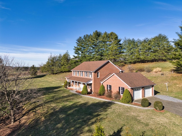 195 Showalter Rd NW, Willis, VA 24380 - view of front of house with gravel driveway, brick siding, covered porch, a front lawn, and a garage