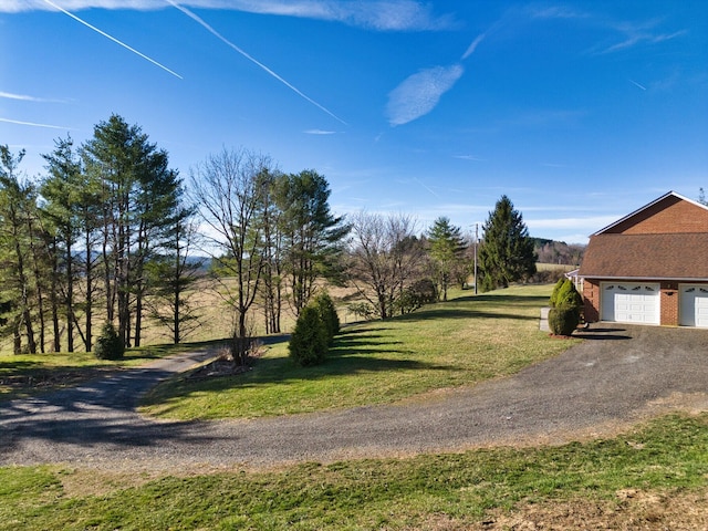 195 Showalter Rd NW, Willis, VA 24380 - view of green lawn featuring a garage and asphalt driveway