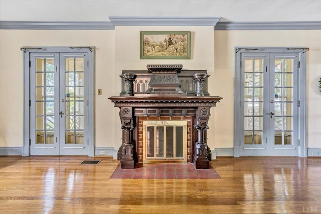living room featuring french doors, plenty of natural light, ornamental molding, and visible vents