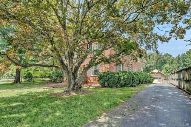 view of property exterior featuring fence, a garage, crawl space, brick siding, and a lawn