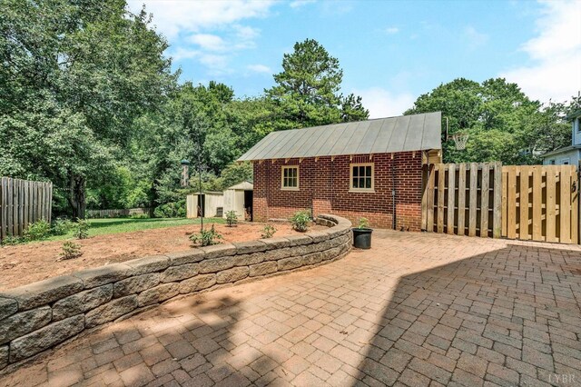 view of patio featuring an outbuilding, fence, and a storage unit