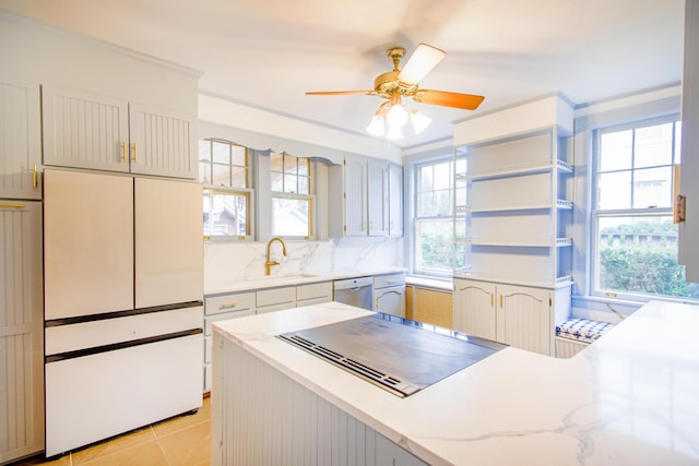 kitchen featuring a sink, white refrigerator, dishwasher, a ceiling fan, and light stone countertops