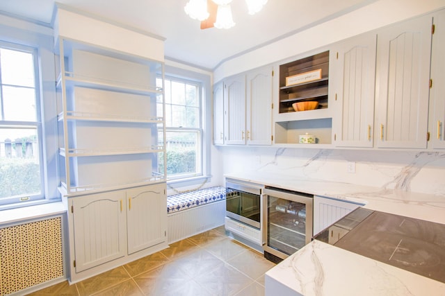 kitchen with open shelves, light stone countertops, tasteful backsplash, radiator heating unit, and beverage cooler