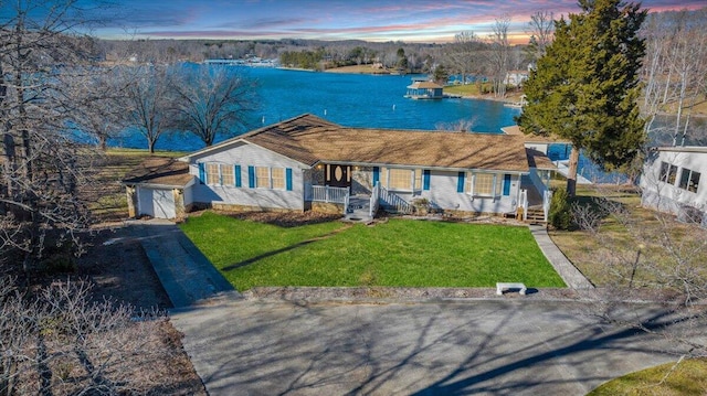 view of front facade with a water view and a front lawn