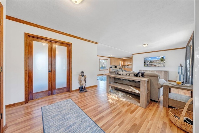 living area featuring french doors, ornamental molding, and light wood finished floors