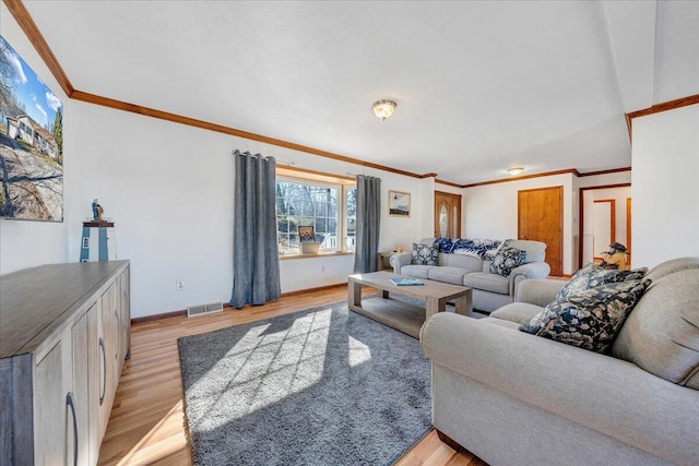 living room featuring baseboards, light wood-style flooring, visible vents, and crown molding