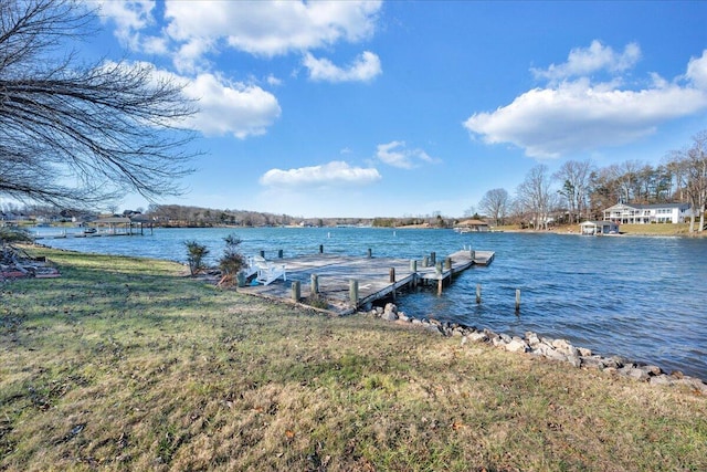 view of dock with a water view and a yard