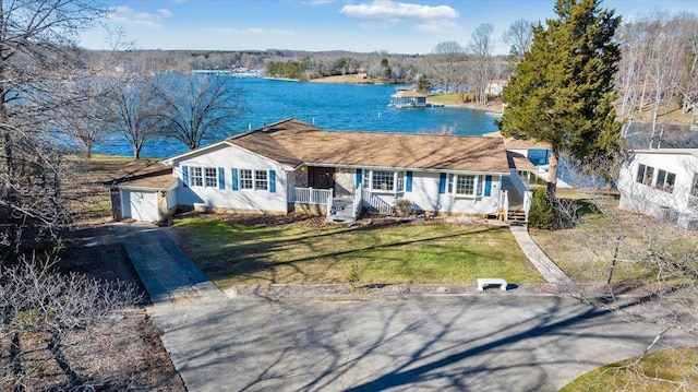 ranch-style home featuring a water view, a garage, a front lawn, and concrete driveway