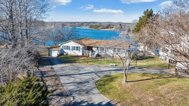 view of front of property featuring driveway, a water view, and a front lawn