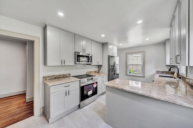 2619 Carolina Ave SW, Roanoke, VA 24014 - kitchen with stainless steel appliances, a sink, light stone counters, recessed lighting, and a peninsula