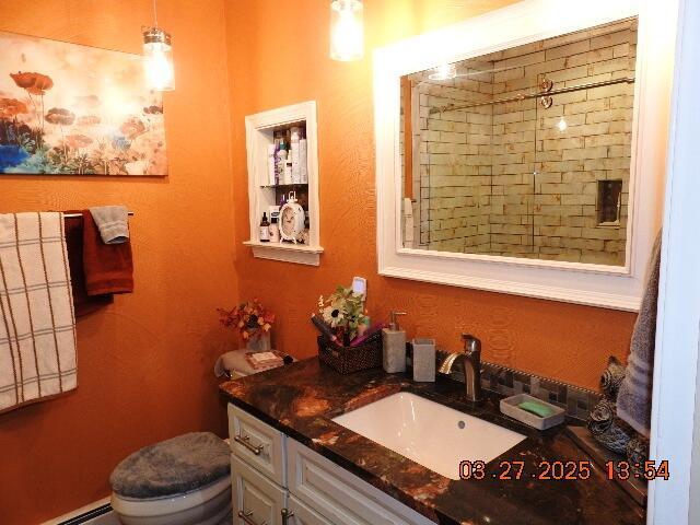 bathroom with a baseboard radiator, toilet, and vanity