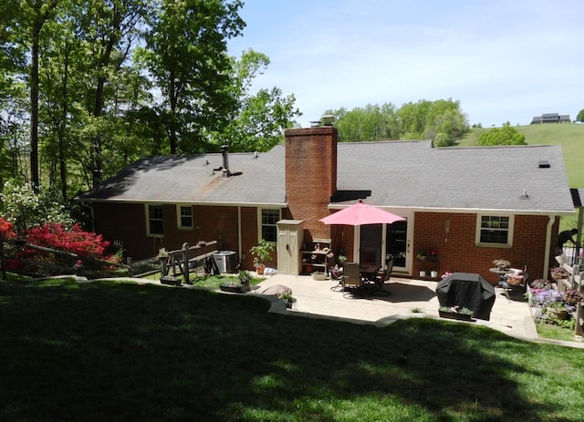 back of property featuring a patio area, brick siding, a yard, and central AC unit