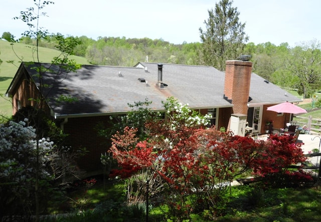 exterior space with a chimney and brick siding