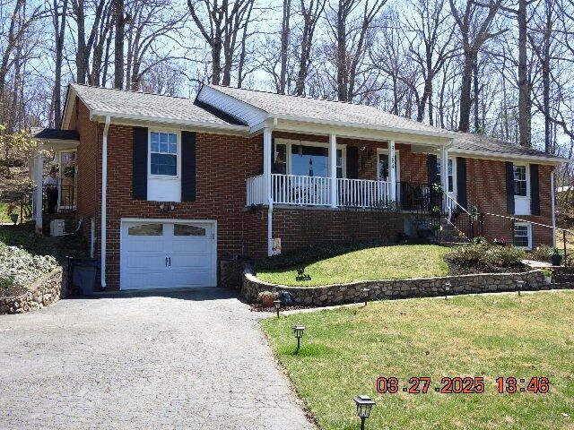 single story home featuring brick siding, an attached garage, and aphalt driveway