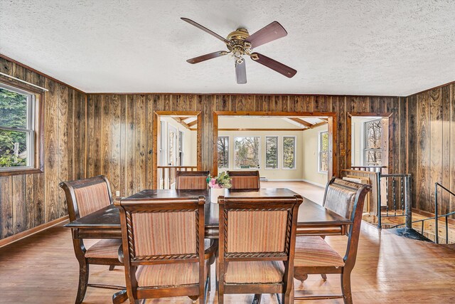 bedroom featuring baseboards, a textured ceiling, wood finished floors, and a ceiling fan