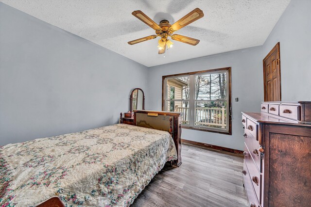 unfurnished living room with wooden walls, wood finished floors, ceiling fan, and a textured ceiling